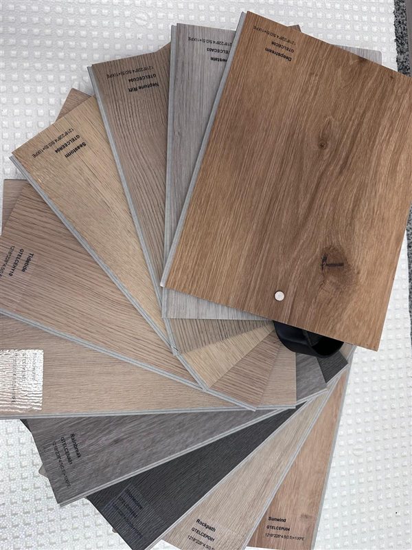 Aufgefächertes Musterbuch mit Design-Boden-Dekoren in verschiedenen Holztönen, jedes Muster benannt und mit Artikelnummer